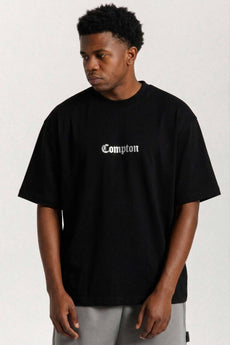 Modelo vestindo a peça: Camiseta Compton Oversized Logo Refletivo Preto